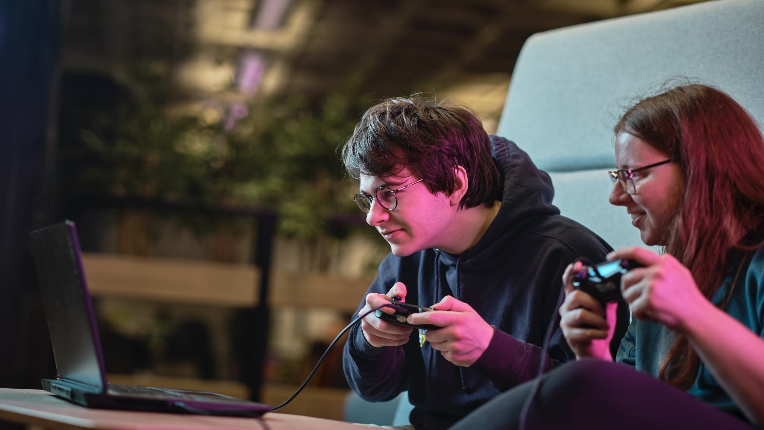 Two students gaming with consoles