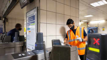 A man sampling London Underground gates for COVID-19. 