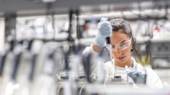 A female researcher pipetting in a laboratory.